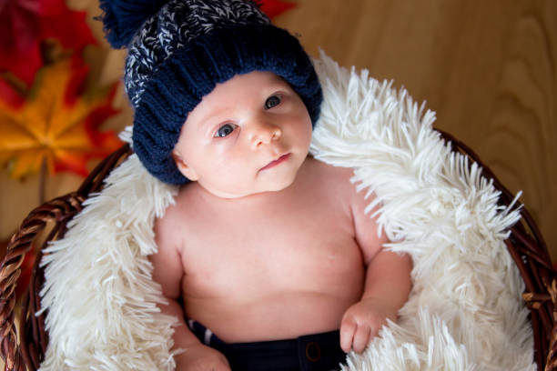 istock Cute newborn baby boy with knitted hat in a basket 849999012