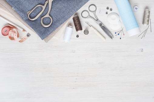 Varios tela y herramientas de costura en la mesa de madera blanca photo
