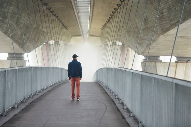 Man under highway brige in mysterious morning fog