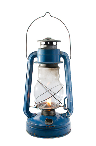 A kerosene lamp on a white background with lit fuse