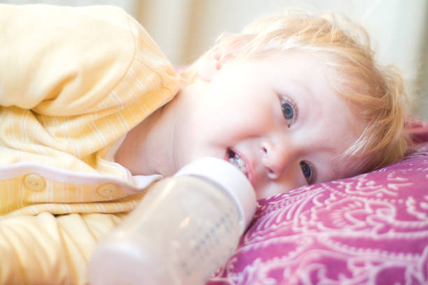 istock blonde child drinks infant formula from a bottle with a pacifier 850109606