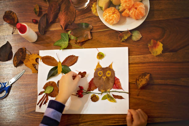 istock Sweet child, boy, applying leaves using glue while doing arts and crafts in school 850113394