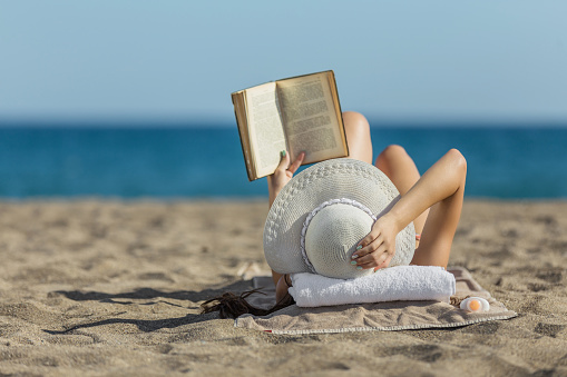 Woman on the beach reading a book