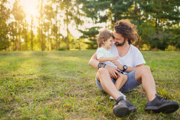 istock Father son hugging on the grass in the park. 850132758