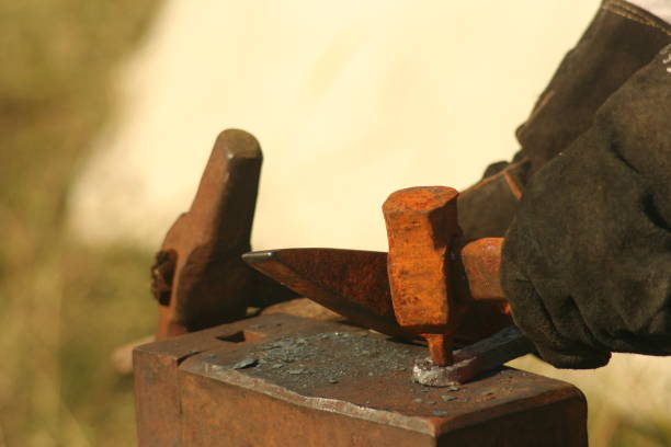 istock Blacksmith working process. Close-up of anvil and blacksmith hand holding hummer 850141240