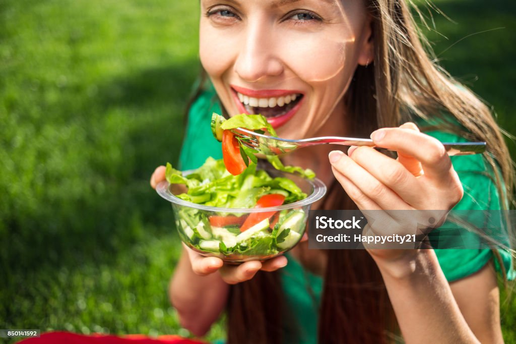 Woman eating healthy salad Woman eating healthy salad, focus on eyes and salad Eating Stock Photo