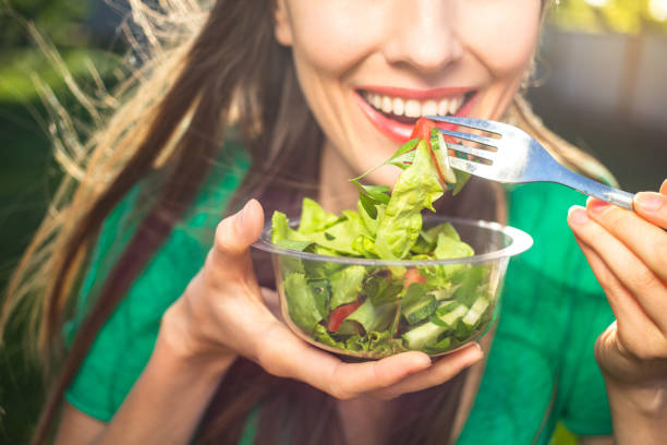 mujer comiendo ensalada saludable - appetizer lunch freshness vegetable fotografías e imágenes de stock