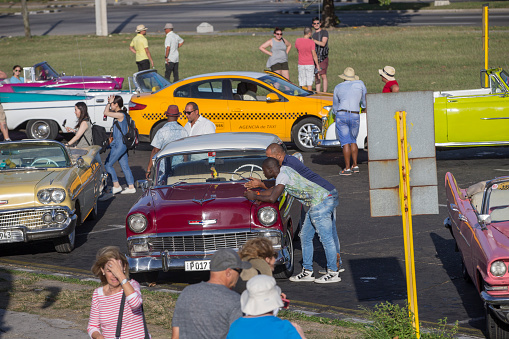 Antique cars parking on the side. Incidental people on the background.