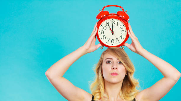 istock Serious girl with alarm clock on blue. 850144874