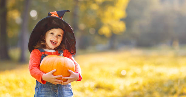 istock child girl with pumpkin outdoors in halloween 850145006