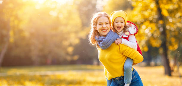 szczęśliwa matka rodziny i córka dziecka na jesiennym spacerze - women autumn people leaf zdjęcia i obrazy z banku zdjęć