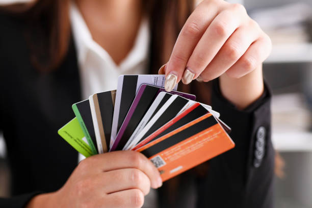 女性の腕がクレジット カードの束を保持します。 - ローン ストックフォトと画像