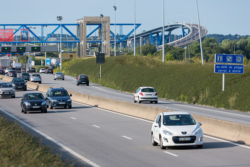 Le Havre, France - August 24, 2017: Toll station with passing cars at bridge Pont de Normandie over river Seine