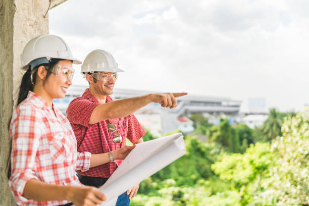 istock Multi-ethnic diverse couple of happy civil engineer work together on building blueprint. Architect interior industry, teamwork meeting, outdoor construction site survey, or consultant advice concept 850186832