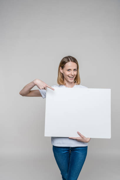 istock woman pointing at blank board 850196498