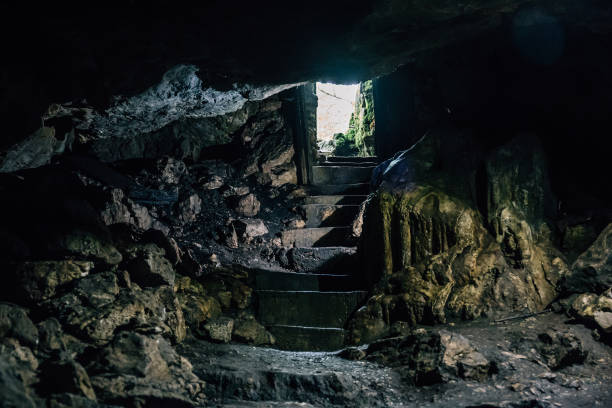 istock Dark cave with steps of staircase and light from entrance 850203794