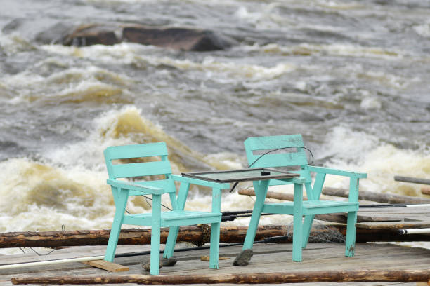 Fishermens chairs stand abonded on a pier into Torne älv, Sweden. Seen at Kukkolaforsen