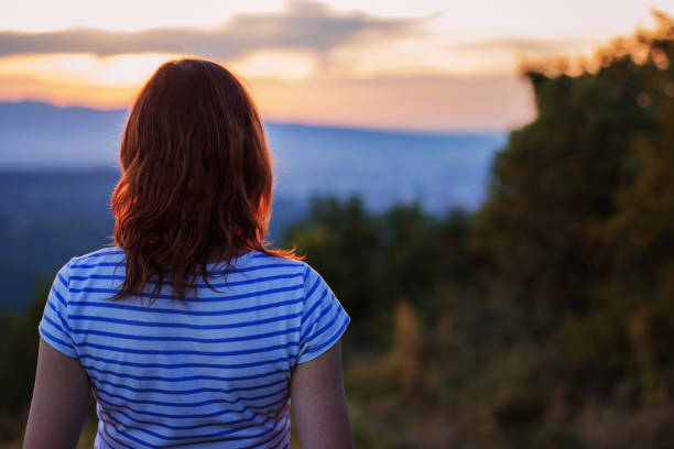 istock Young woman watching sunset 850259750
