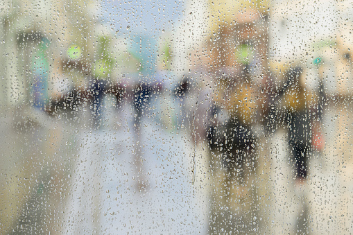 Raindrops on a glass with defocused cityscape at background