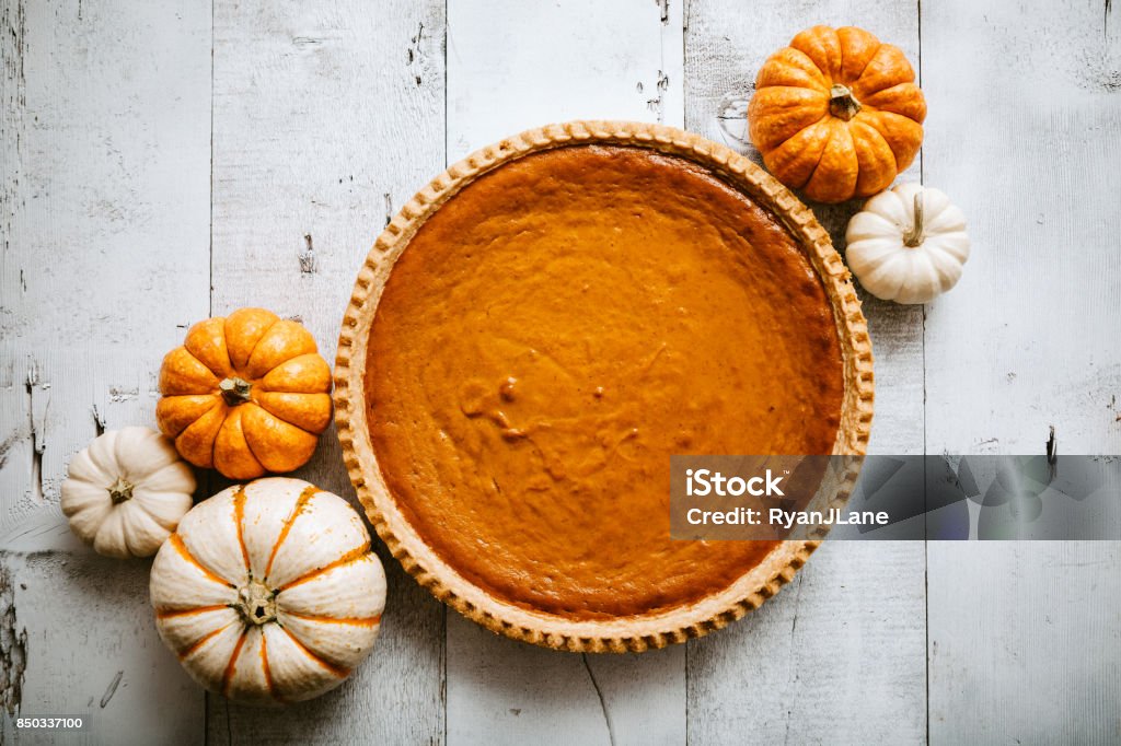 Pumpkin Pie on Rustic Background A high angle view looking down on a freshly baked pumpkin pie, just in time for your autumn or Thanksgiving season celebration.  Small decorative gourds decorate the scene.  Horizontal image with copy space. Pumpkin Pie Stock Photo
