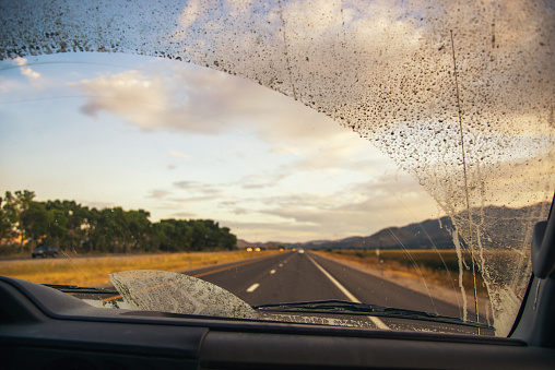 Road through the dirty truck windshield, focus on the wiper