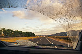 Road through the dirty truck windshield, focus on the wiper