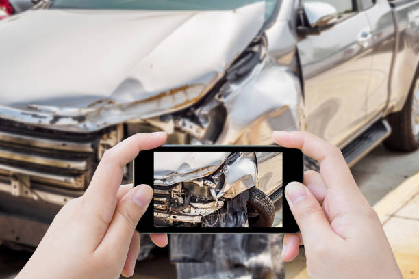 mujer con móvil smartphone tomar foto de daños para el seguro de accidente de coche - accidente de automóvil fotos fotografías e imágenes de stock