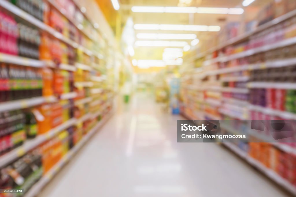 allée de supermarché avec produit de bouteilles de boisson gazeuse étagères arrière-plan flou - Photo de Supermarché libre de droits