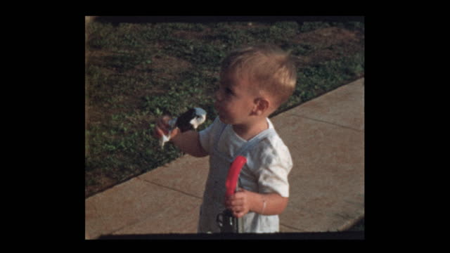 Adorable blonde little boy eating ice cream on a stick