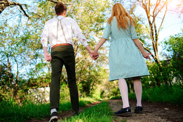istock man goes with his girlfriend on the road, low angle, Back view 850423016