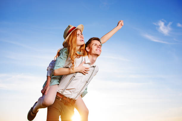 istock Young man piggybacking his happy girlfriend with raised hand. Cheerful lovers dreaming 850426018