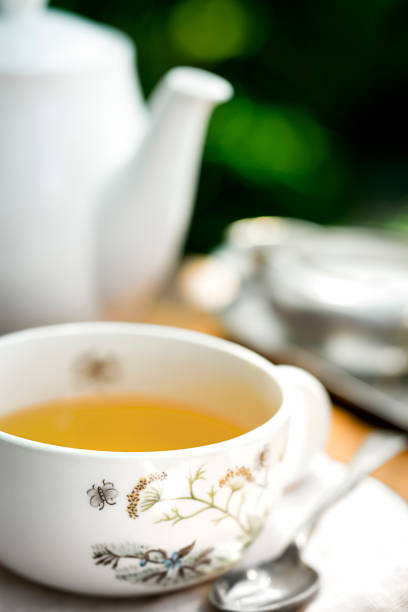Porcelain cup and saucer and teapot for tea served in the garden in a vintage style.