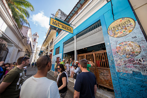 People walking and taking pictures in front of La Bodeguita del Medio restaurant in Old Havana, Cuba
