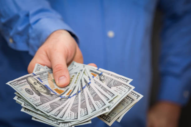 istock Holding Out Fanned Hundreds 850488656