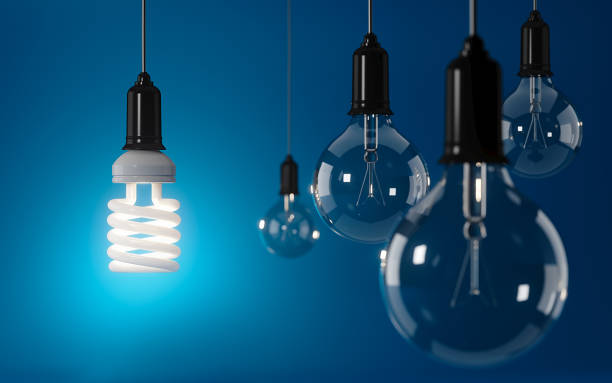 istock Energy Saving Light Bulb Standing Out From The Crowd Over Blue Background: Energy Efficiency and Standing Out From The Crowd Concept 850502940