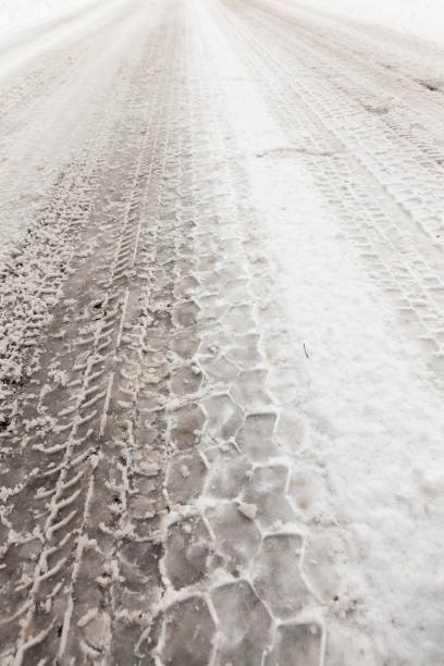 istock car tire imprint on the snow melted 850509116