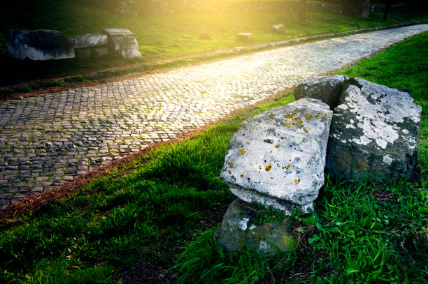 Ancient roman ruins along Appian road side in the early morning in backlight