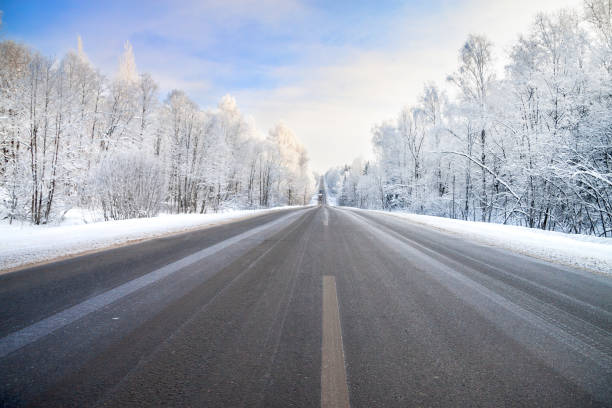 冬のアスファルトの道路、森林、青い空のある風景。 - landscaped landscape winter usa ストックフォトと画像