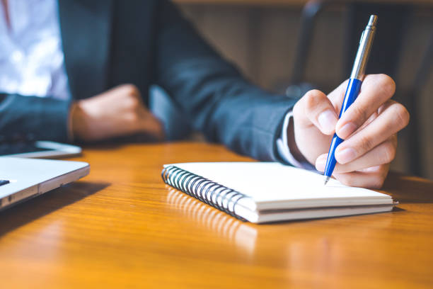 istock business woman hand  writing on notepad with a pen in office. 850633724