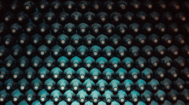 stacked up wine bottles in the cellar stock photo