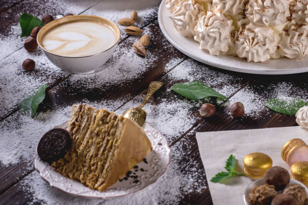 Beautifully decorated dessert table where the cake with meringue on a dark wooden table. Arrangement of delicious sweets