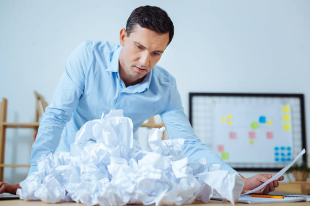 istock Confused office worker looking at crumpled paper 850685022