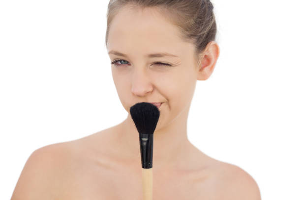 istock Playful brunette model holding a brush and winking at camera 850696756
