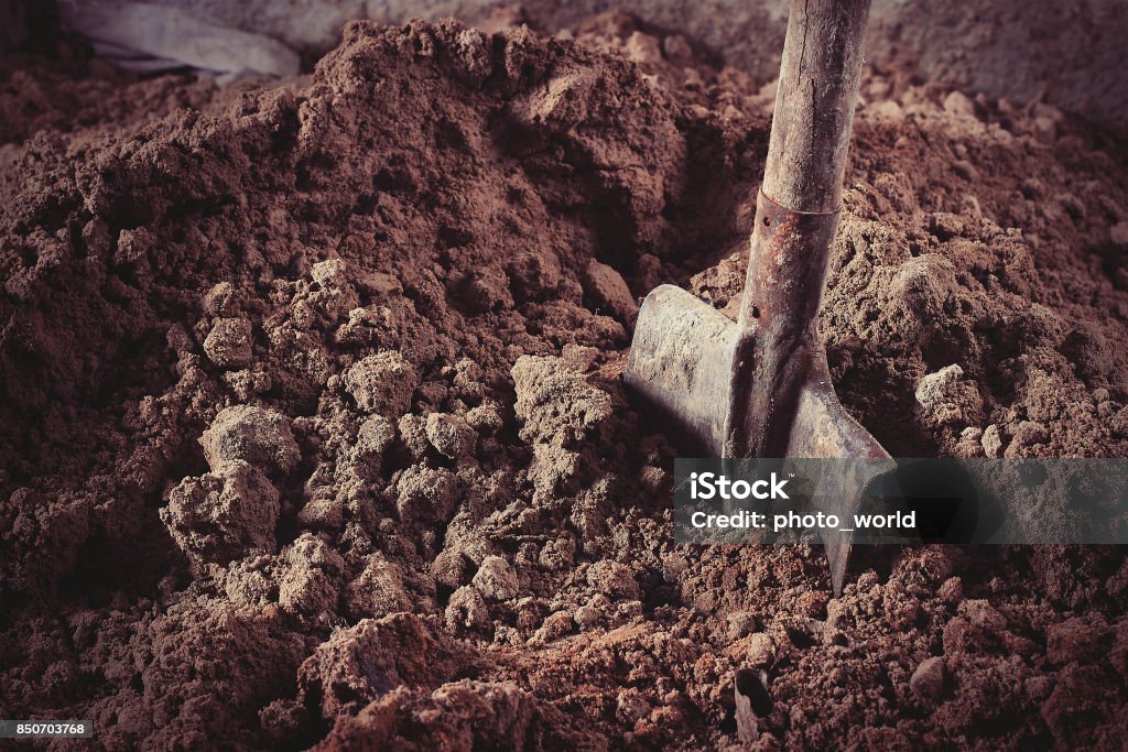 Shovel in sand Old rusty shovel in sand on building. Shovel Stock Photo