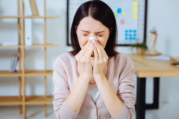 istock Ill female person sneezing at work 850705780