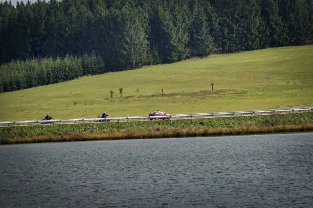 Photo of motorbikes and a car going through the dam
