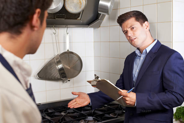 inspector de salud reunión con chef en cocina de restaurante - food hygiene fotografías e imágenes de stock