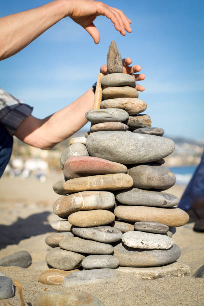 istock man's hands makes pyramid of stones 850713458