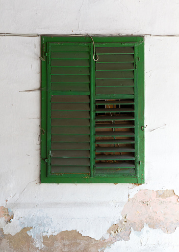 Green shutter on an old wall