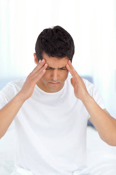 istock Handsome man having a headache sitting on his bed at home 850760524